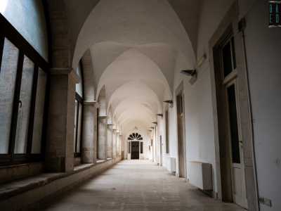 Dopo pochi passi scorgiamo un alto portone in legno, soglia d�accesso dell�istituto. Dinnanzi a noi si aprono cos� due lunghi corridoi coperti da volte a crociera che poggiano su pilastri quadrangolari, lascito del quattrocentesco convento dei Carmelitani
